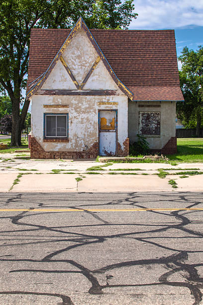 Small commercial building, empty and deserted, Salina, Kansas, interesting graphic pattern in the street in the foreground, plenty of sunshine, early summer.