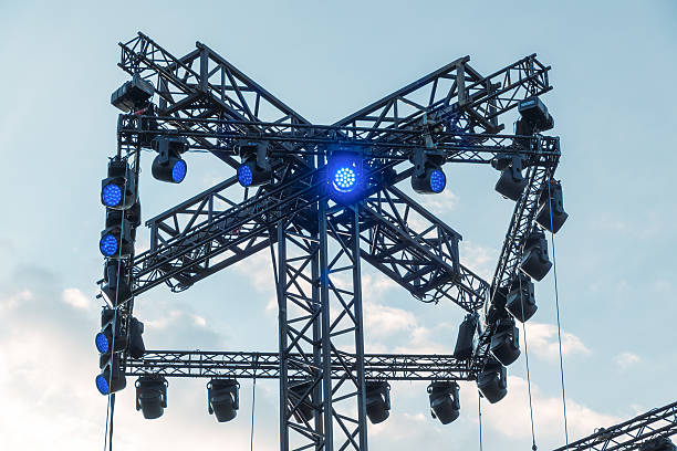 istock Outdoor stage lighting rig with blue spotlights against sky 2222534898