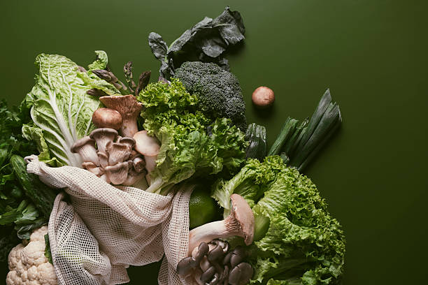 istock Fresh green vegetables and herbs in an eco-friendly storage bag on a green backdrop for healthy meal preparation 2222536065