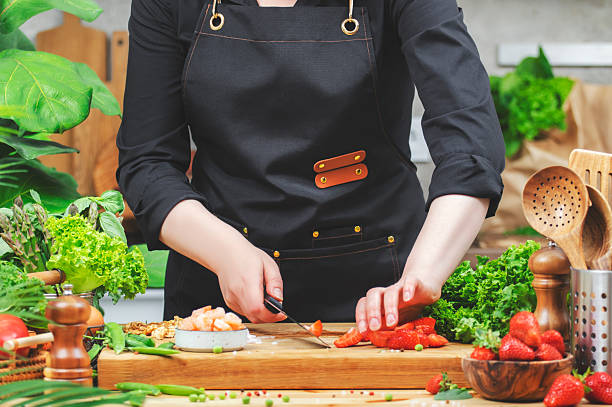 istock chef skillfully chops vegetables on a wooden cutting board in a lively kitchen adorned with fresh produce and plants, promoting healthy eating. 2222536077
