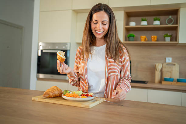 istock Smiling woman enjoying a healthy breakfast in her modern kitchen 2222546337