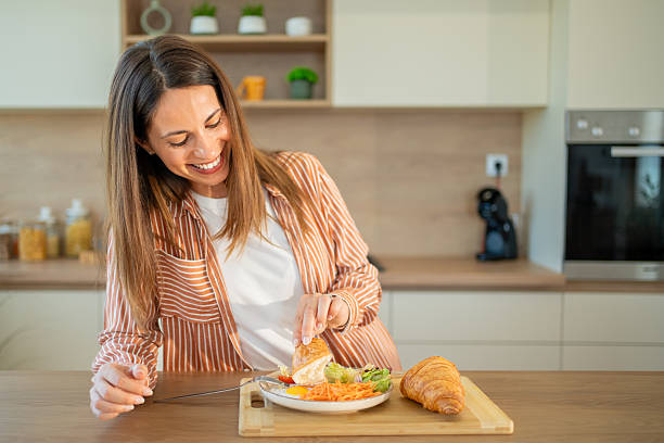 istock Smiling woman enjoying a healthy breakfast in her modern kitchen 2222546340