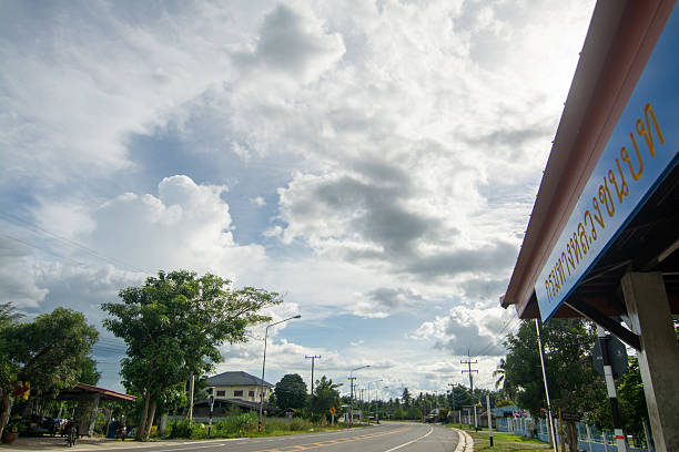 Thai rural highway landscape under the wide sky.
