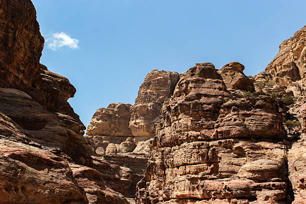 istock Towering Layered Sandstone Cliffs Against a Clear Blue Sky in a Jordanian Canyon 2222549219