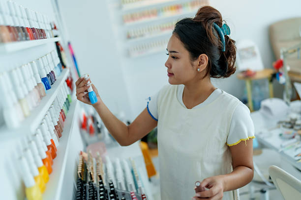 istock Skilled hand carefully selects vibrant nail polish from colorful array, showcasing beauty of manicure artistry. This moment captures essence of creativity and self expression in beauty 2222549369