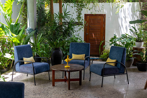 istock Tranquil patio scene featuring comfortable blue armchairs amidst tropical greenery, creating a serene and inviting space 2222553528