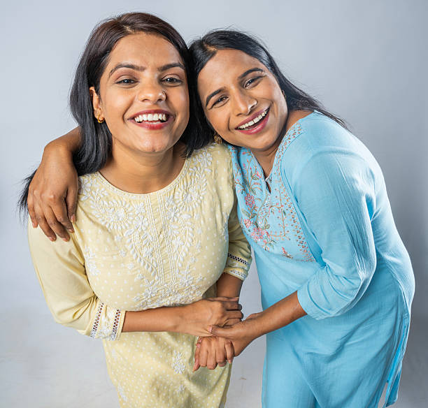 istock Female friends smiling and standing on white background 2222553914