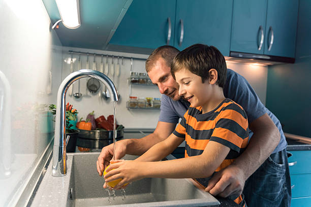 istock Father and Son Washing Vegetables Together Joyfully 2222555464