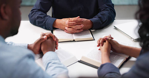 istock Diverse Group Praying Together, Studying Bible In Local Church 2222555631