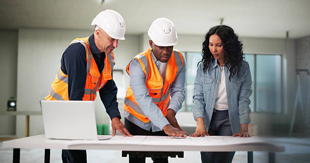 istock Engineers Inspecting Blueprint Of House Remodel With Client 2222555733