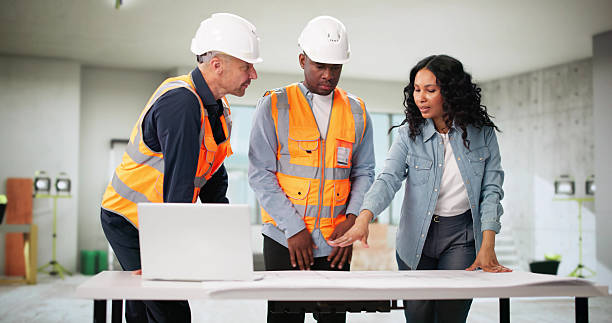 istock Engineers Inspect Blueprint Of House Remodel With Client 2222555745