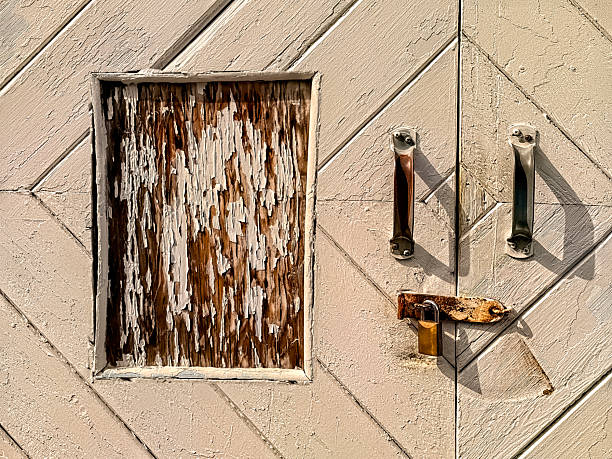 This is a horizontal, color photograph of an exterior, industrial, metal warehouse wall door texture background in Granville Island Vancouver, BC Canada. The white paint is chipped, peeling, weathered, gritty and rusty. Photographed with a Nikon D800 DSLR camera.
