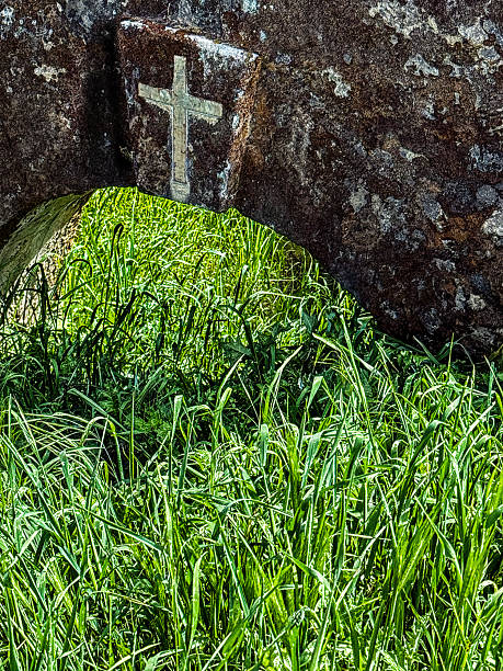 istock Christian religious cross on a stone arch in a grass field. 2222556215
