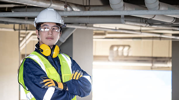 istock Asian male engineer standing with arms crossed looking away at construction site 2222557011
