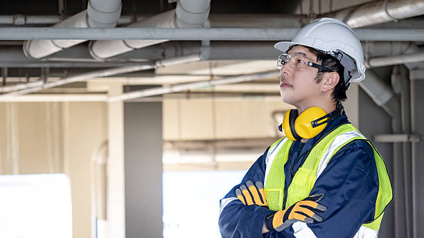 istock Asian male engineer standing with arms crossed looking away at construction site 2222557012