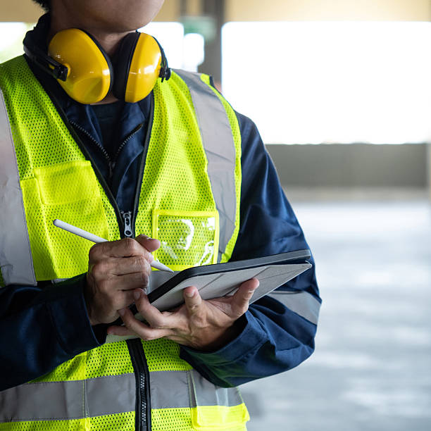 istock Asian man building inspector in reflective vest using digital tablet working for building maintenance inspection 2222557341