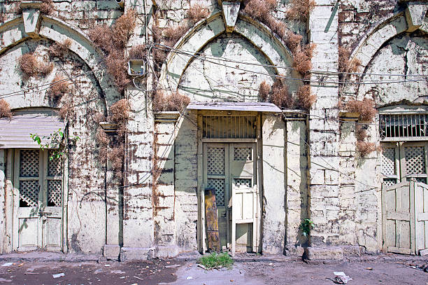 Weathered warehouse, Junaghad Mullawada, Gujarat, India. Mullawada is a locality within the historic city of Junaghad, renowned for its architecturally significant sites, including temples, step wells and old imperial buildings but also for being one of the most contentious regions during the period of Partition in 1947. Gujarat, the north western state of India,  encompasses part of site of the Indus Valley civilisation, the oldest known to mankind and is also home to some of the most historic sites and religious locations in India. The Rann of Kutch is famous for its arid desert like landscapes as well as wildlife such as the Wild Ass, together with Gir Forest, home to the only Asiatic Lions in the continent.