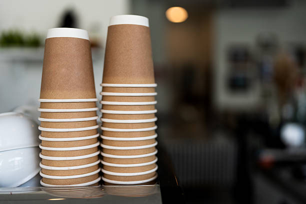 istock Stacks upside down empty brown takeaway disposable coffee cardboard cups on the coffee machine 2222562105