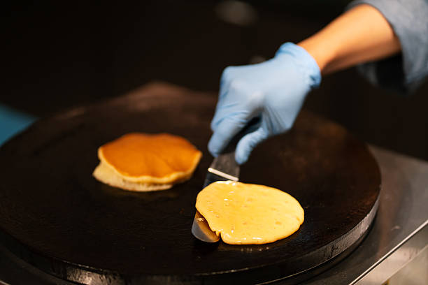 Pancakes batter baking on the frying pan in kitchen
