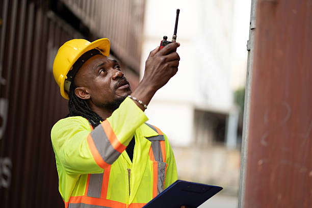 istock African worker working with use clipboard and walkie talkie checking container at container site 2222571143