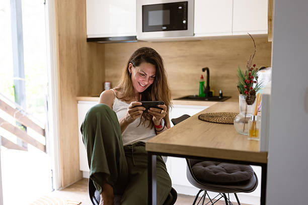 istock Relaxed Woman on Smartphone in Modern Kitchen 2222571220