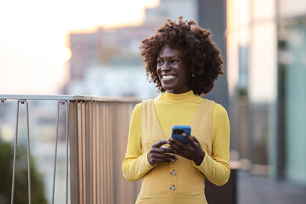 istock Smiling woman uses smartphone while enjoying a sunny afternoon 2222572356