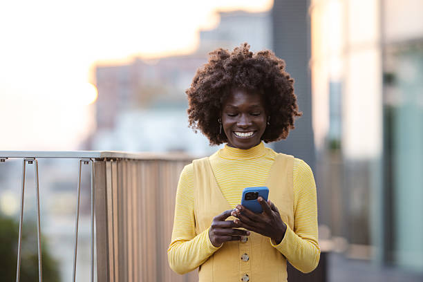 istock Smiling woman outdoors texting on her smartphone during a beautiful sunset 2222572357