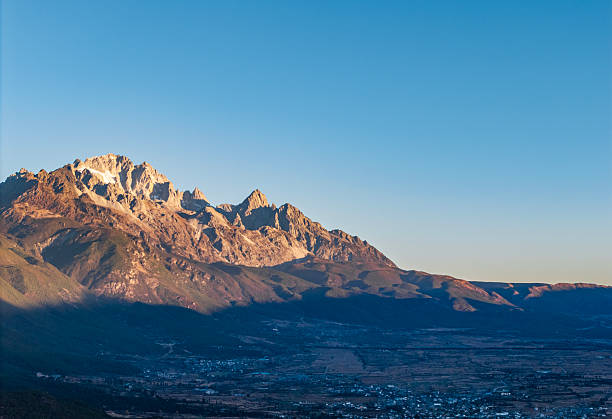 The landscape of Yulong Snow Mountain bathed in sunlight on golden mountains