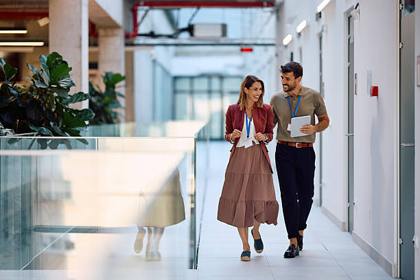 istock Happy business colleagues walking through office hallway. 2222583493