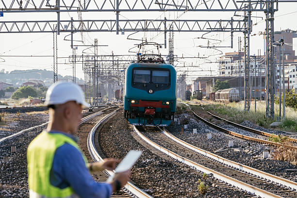 Senior railroad engineer examines the innovative integrated network system for passenger and freight railways