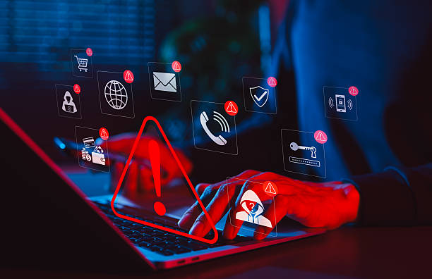 online scam alert and cybersecurity warning concept. man holding phone while using laptop, warning sign for scam with icons online threats, phishing, cyber secure, unknown person, suspicious scammer, - burlão imagens e fotografias de stock