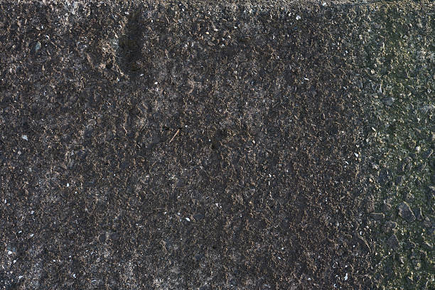 istock Background material of cracked concrete that has weathered and turned black 2222588701
