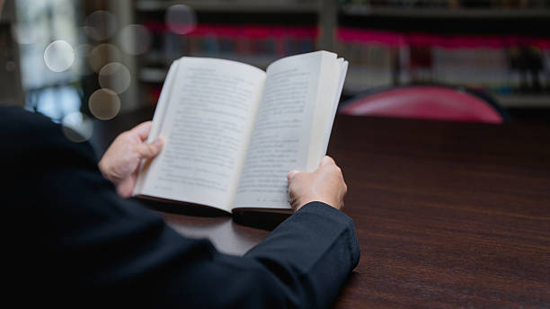 istock Lost In Thought Dark Study Scene With Open Book, Bokeh Lights, And Soft Text, Perfect For Intellectual Pursuits, On Wooden Table Background 2222601445