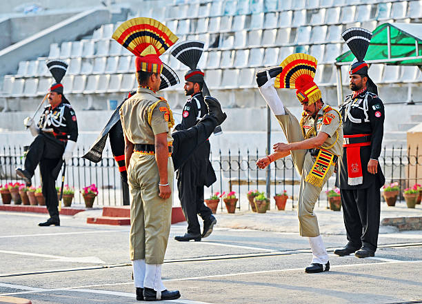 High-kicking performance, Attari-Wagah Border Ceremony, Punjab, India. The daily ceremony at the Attari–Wagah border is performed by the security forces of India (Border Security Force) and Pakistan (Pakistan Rangers) and is symbolic of the brotherhood and rivalry that the two nations share. The flag lowering ceremony is held each evening immediately before sunset, beginning with battle calls from both sides followed by a series of high kicks, stomps, and dance moves with opposing forces staring each other down. The event ends with a handshake of good faith along with the lowering of the flags. The Punjab, is the state which is the heart of India’s Sikh community, bordering Pakistan. The city of Amritsar is best known for Harmandir Sahib, the holiest gurdwara, or Sikh place of worship and a major pilgrimage site. The distinctive Golden Temple, as it is known in English, is surrounded by the Pool of Nectar.