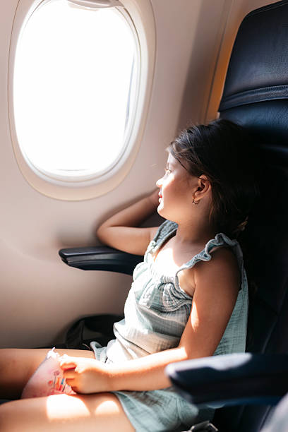 istock Little girl looking through airplane window during flight 2222602752