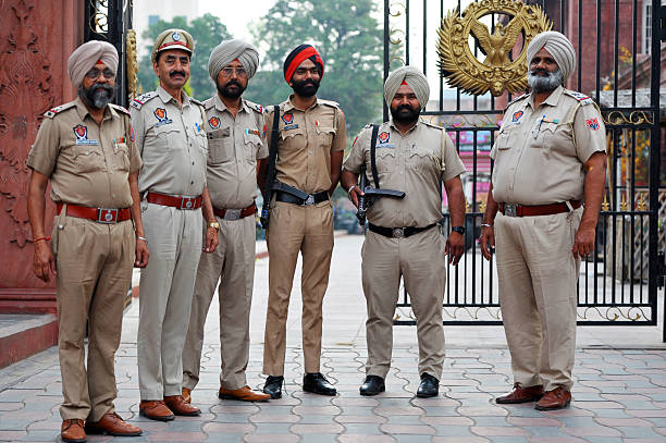 Security force members at dawn outside Partition Museum, Amritsar city, Punjab, India. Amritsar is a city rich in Sikh heritage and history being a major pilgrimage centre, especially for the Golden Temple, but also for Partition in 1947. The Heritage Walk explores its traditional architecture, historic lanes, Katras, Akharas, Bungas, Havelis, and Hattis. The Punjab, is the state which is the heart of India’s Sikh community, bordering Pakistan. The city of Amritsar is best known for Harmandir Sahib, the holiest gurdwara, or Sikh place of worship and a major pilgrimage site. The distinctive Golden Temple, as it is known in English, is surrounded by the Pool of Nectar.