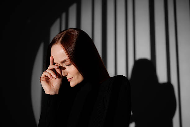 istock Woman in turtleneck posing in light on grey background with shadow 2222603361