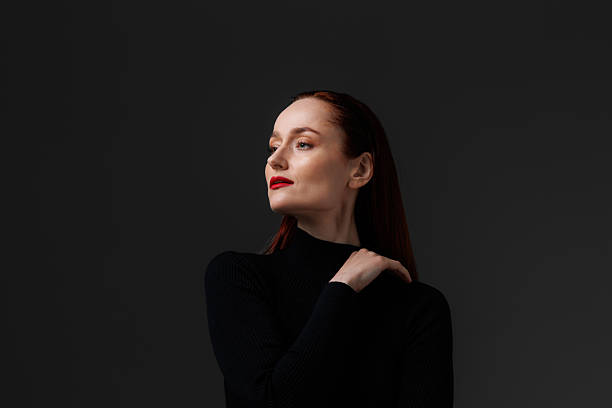 Elegant woman with red lips looking away isolated on grey