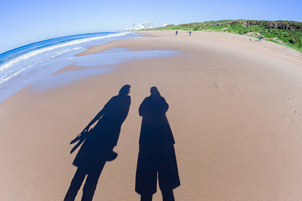 istock Man Woman Beach Shadow Reflections Landscape 2222604157