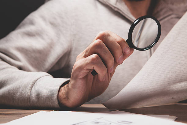 istock magnifying glass on a man 's hand. 2222608439