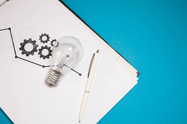 light bulb with notepad on a white paper background with a crumpled paper.