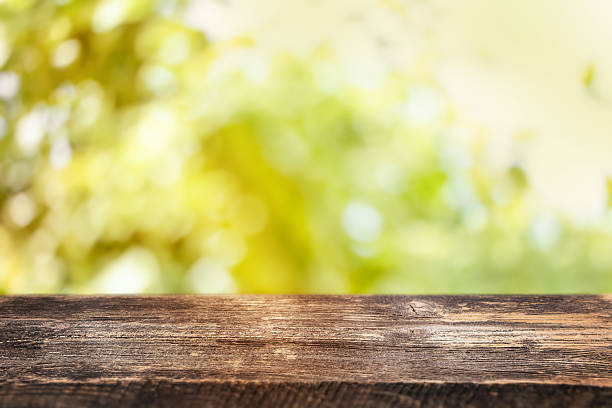 istock A rustic wooden table with a sunny, blurred green background evokes the warmth and freshness of outdoor gatherings and natural living 2222608914