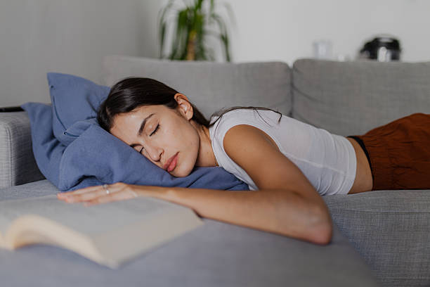 istock Young Woman Sleeping on Sofa after Reading a Book 2222611823