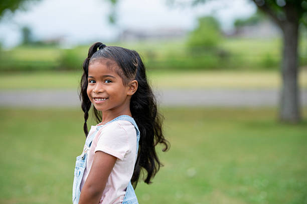 istock Smiling Young Girl Outdoors in a Green Nature Park Setting 2222612639
