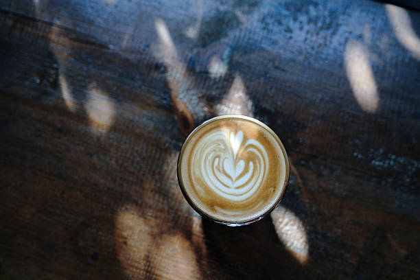 istock Heart-shaped latte art in coffee cup on rustic wooden table 2222613290