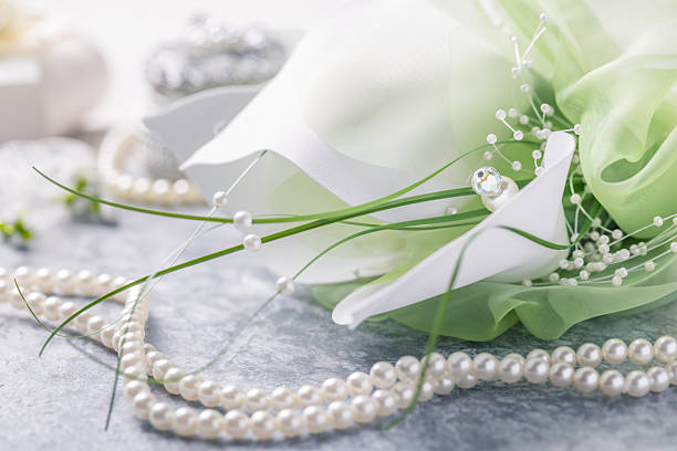 White chrysanthemum and pearls on white background with space for message