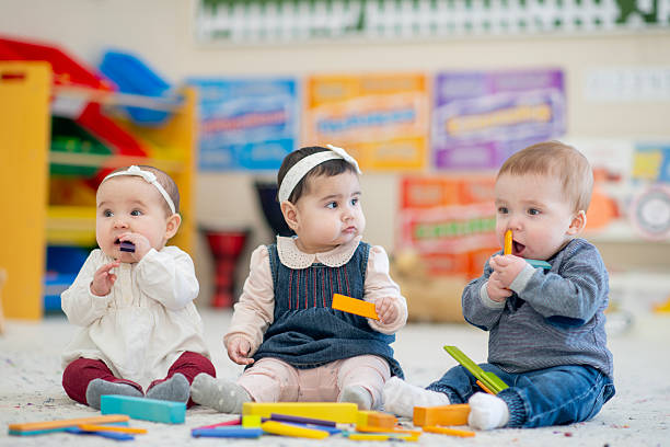 istock Group of Babies Playing With Colorful Blocks in a Nursery 2222616743