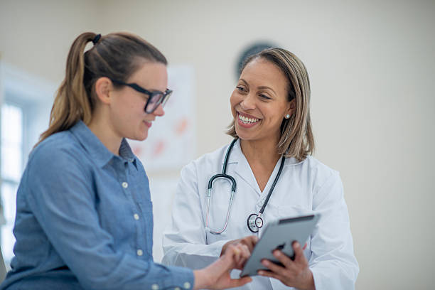 istock Doctor Consulting Smiling Patient During Visit with Tablet in Hand 2222616899