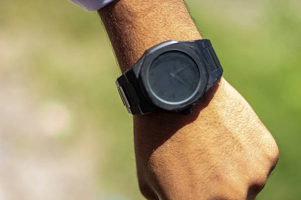 istock A man's hand holding a watch and a green background blur 2222617288