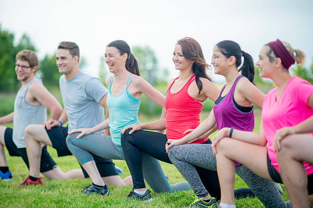 istock Group Fitness Class Outdoors Featuring Stretching and Smiling Participants 2222618169